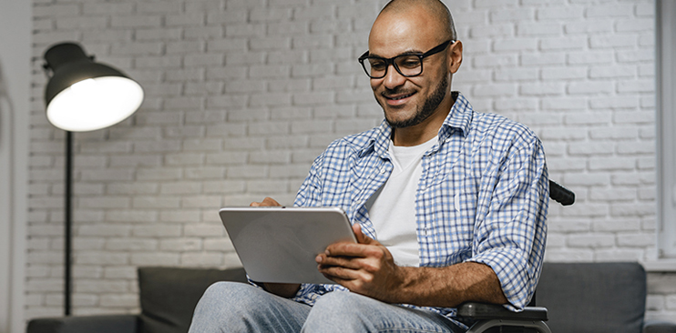 Man sitting in his wheelchair working on his laptop.
