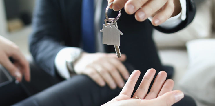 Keys being handed to new homeowner from agent.