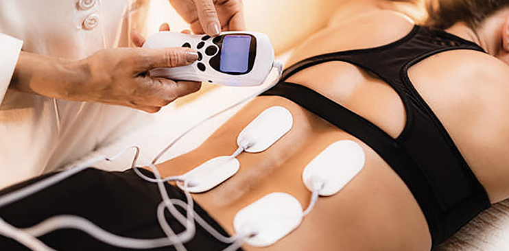 Woman receiving neuromodulation therapy on her back. 